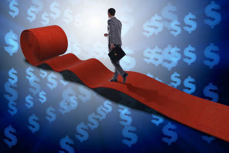 Businessman with dollars on red carpetの写真素材