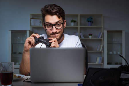 Young man playing games long hours late in the office