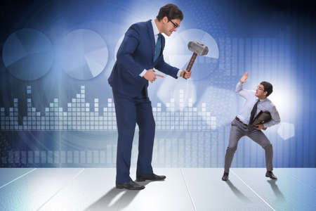 Bad angry boss threatening employee with hammerの写真素材