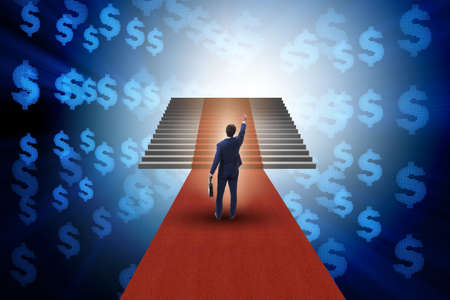 Young businessman climbing stairs and red carpetの写真素材