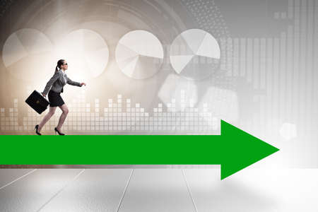 Businesswoman walking on arrow signの写真素材