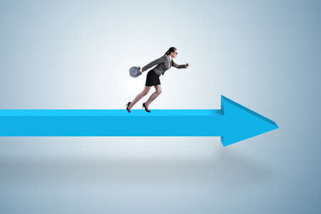 Businesswoman walking on arrow signの写真素材