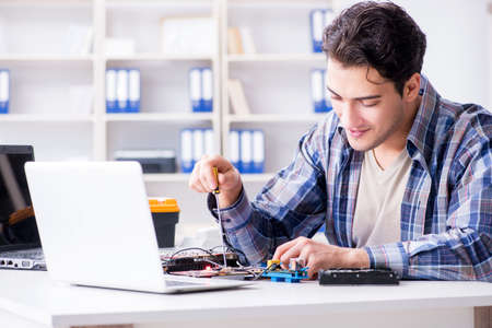 Professional repairman repairing computer in workshop