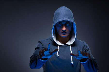 Young man wearing hoodie pressing virtual buttonsの写真素材