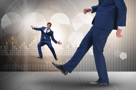 Bad angry boss kicking employee in business conceptの写真素材