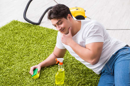 Young husband man cleaning floor at homeの写真素材