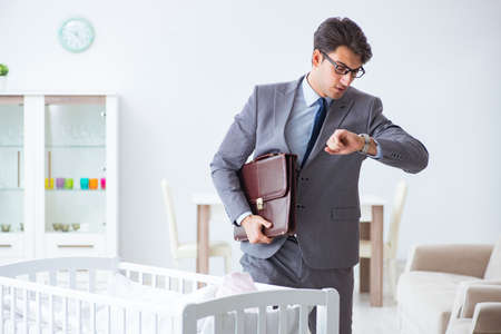 Young businessman trying to work from home caring after newborn babyの写真素材