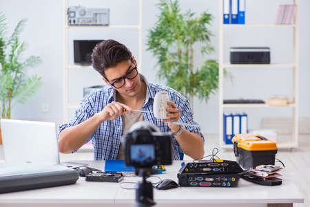 Vlogger recording computer repair on camera for vlog blog