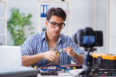Vlogger recording computer repair on camera for vlog blog