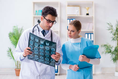 Two doctors examining x-ray images of patient for diagnosis