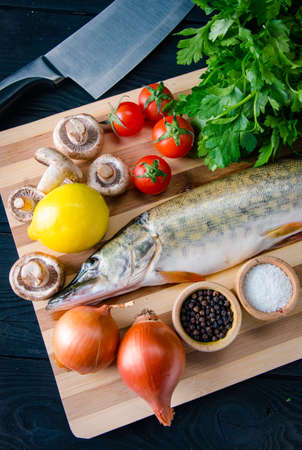 Uncooked fish on cutting board in meal preparation conceptの写真素材