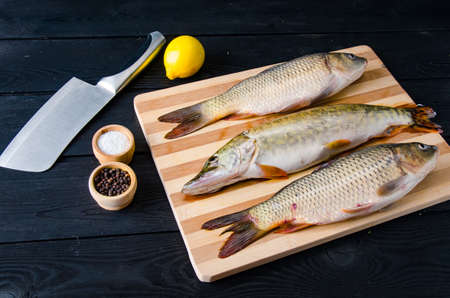 Uncooked fish on cutting board in meal preparation conceptの写真素材