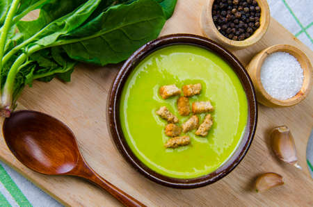 Spinach soup served on wooden board 