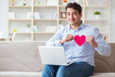 Young man making marriage proposal over internet laptopの写真素材