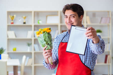 Flower shop assistant offering a bunch of flowersの写真素材