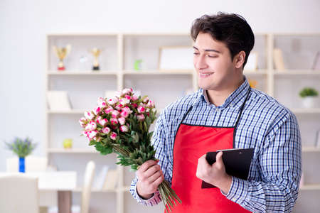 Flower shop assistant offering a bunch of flowersの写真素材