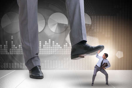 Bad angry boss stamping on employee in business conceptの写真素材