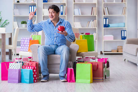 Young man after excessive shopping at homeの写真素材