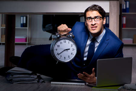 Businessman working overtime long hours late in officeの写真素材