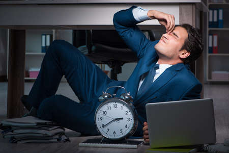Businessman working overtime long hours late in officeの写真素材