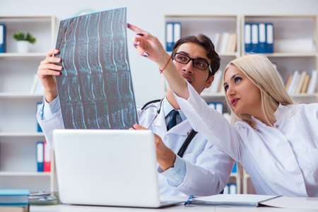 Two doctors examining x-ray images of patient for diagnosis