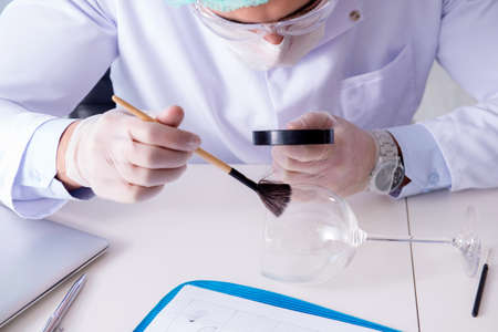 Criminologist police chemist looking at crime evidenceの写真素材