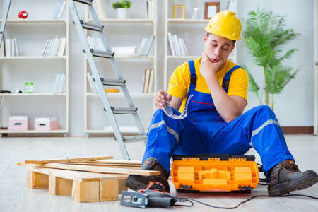 Young man assembling wood pallet