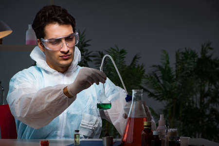 Young male lab chemist late at night in overtime time