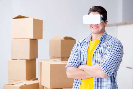 Young man wearing VR glasses moving in new apartment