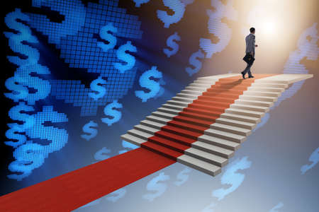 Young businessman climbing stairs and red carpetの写真素材