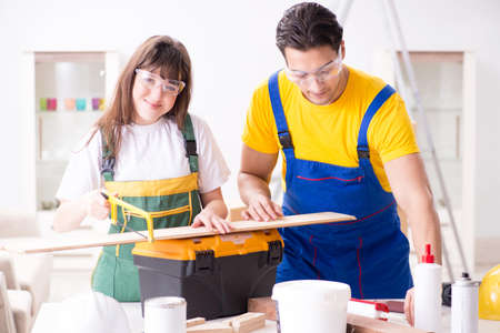 Man explaining woman woodworking tips in wood workshopの写真素材