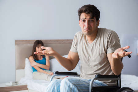 Desperate man on wheelchair with his sad wifeの写真素材