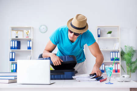 Businessman preparing for vacation in the officeの写真素材