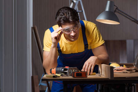 Worker working in repair workshop in woodworking conceptの写真素材
