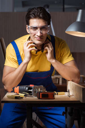 Worker working in repair workshop in woodworking conceptの写真素材