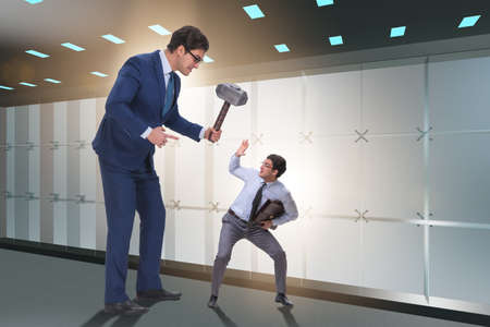 Bad angry boss threatening employee with hammerの写真素材