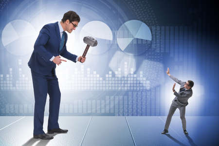 Bad angry boss threatening employee with hammerの写真素材
