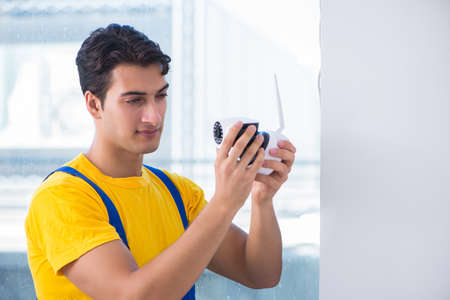 Contractor installing surveillance CCTV cameras in office