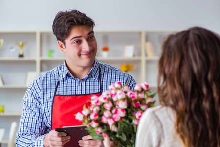 Flower shop assistant selling flowers to female customerの写真素材