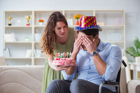 Young family celebrating birthday with disabled personの写真素材