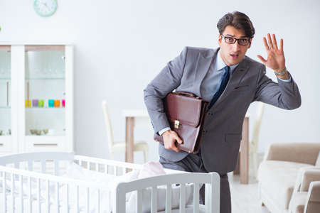 Young businessman trying to work from home caring after newborn babyの写真素材
