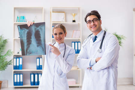Two doctors examining x-ray images of patient for diagnosisの写真素材