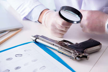 Criminologist police chemist looking at crime evidenceの写真素材