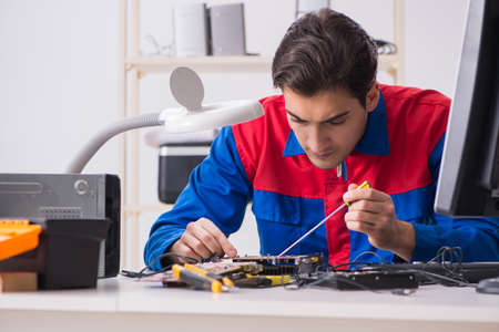 Professional repairman repairing computer in workshopの写真素材