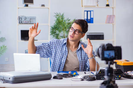 Vlogger recording computer repair on camera for vlog blog