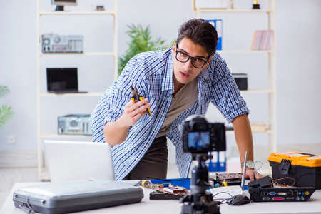 Vlogger recording computer repair on camera for vlog blogの写真素材