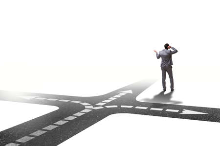 Young businessman at crossroads in uncertainty conceptの写真素材