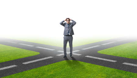 Young businessman at crossroads in uncertainty conceptの写真素材
