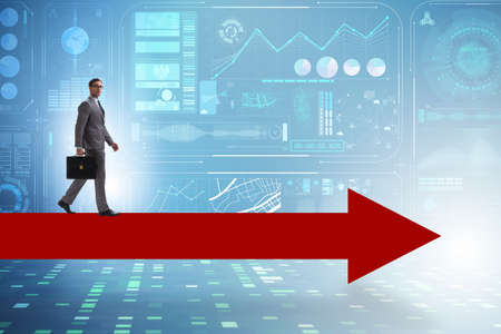Businessman walking on arrow in business conceptの写真素材