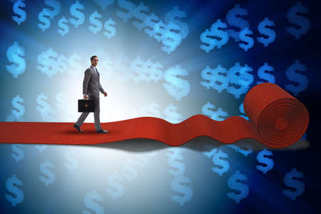 Businessman with dollars on red carpetの写真素材